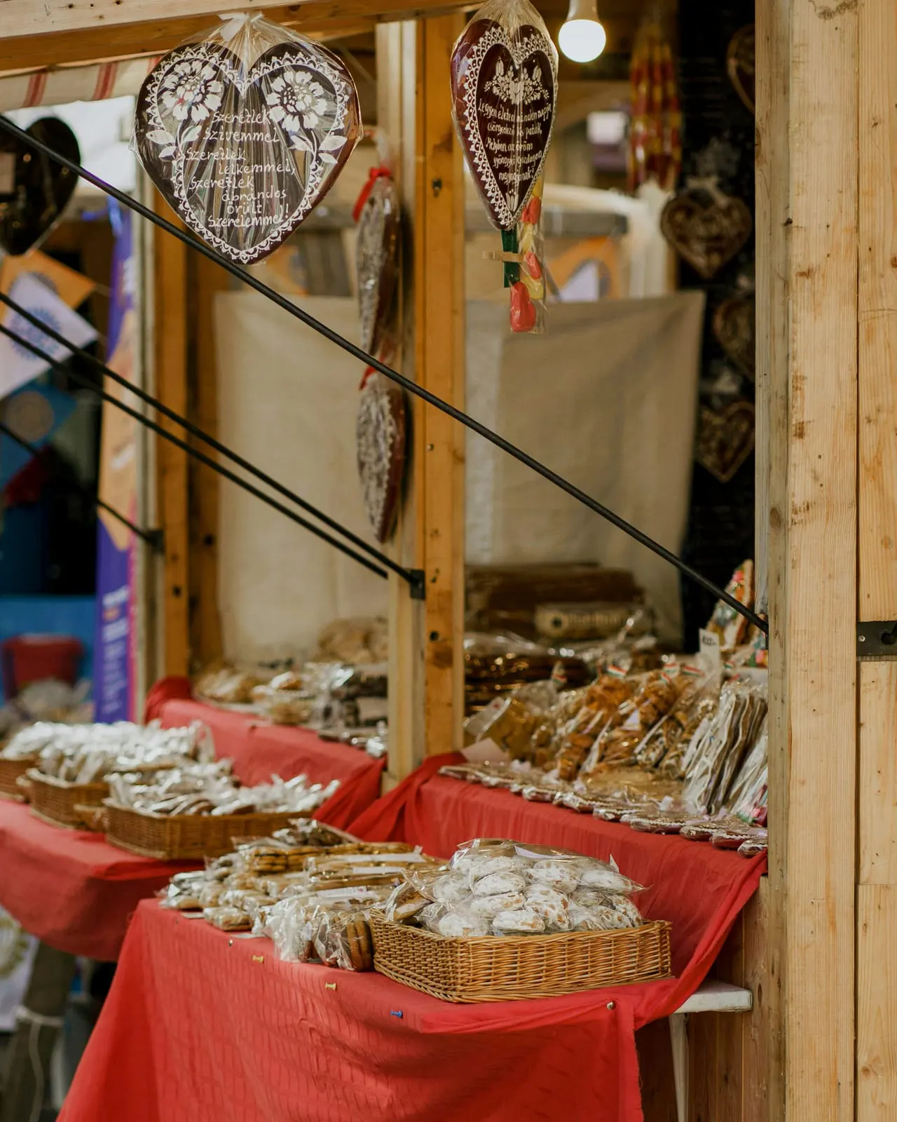 Caseta de madera de pino en una feria de día, con corazones de pan de especias y cestas sobre el mostrador